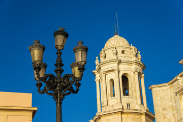 Fototapeta na wymiar Cadiz Cathedral West Tower and Streetlamp against Clear Blue Sky Andalusia