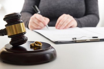 Hands of wife, husband signing decree of divorce, dissolution, canceling marriage, legal separation...