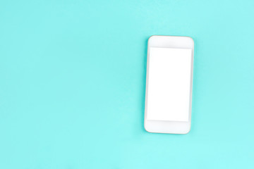 White smartphone on mint background. Flat lay. Space for your text.