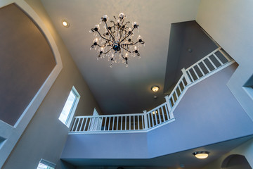 Traditional chandelier in high-ceiling foyer of a contemporary suburban home