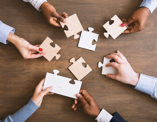 Group of business people assembling jigsaw puzzle together