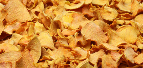 background of slices of orange dried pumpkin. Healthy snack, healthy snack, screensaver, top view