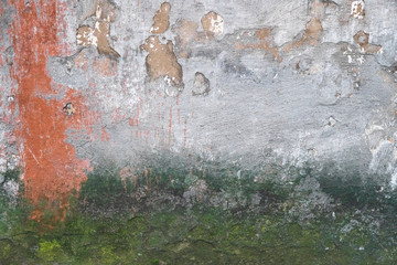 Abstract grunge texture of old colorful wall with cracks and scratches. Creative background. Green, grey and orange rough weathered stone texture with moss, stucco and paint. Copy space