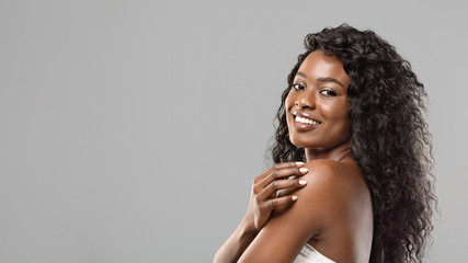 Black Woman With Natural Makeup and White Teeth On Grey Background