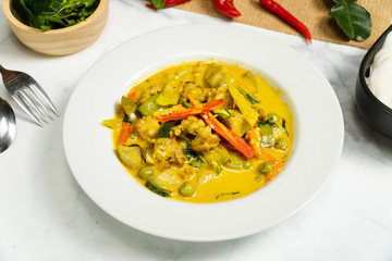 Green curry traditional Thai food name in Thai is Gaeng Kiew Waan in white round ceramic plate