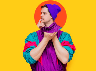 Young man in 90s clothes on yellow background