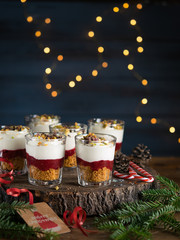 Dessert in a glasses with chocolate and berries spread on wooden background, garland lights bokeh and christmas decoration. Christmas, new year holidays background concept. Dessert recipe ideas.