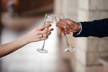 Couple of bride and groom holding glasses of champagne, closeup