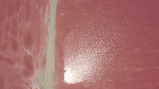 Aerial tilt up on pink salt flats of Las Coloradas, Mexico during daytime.