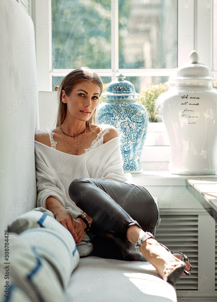 Wall mural relaxing woman sitting comfortable in sofa lounge chair smiling happy looking at camera