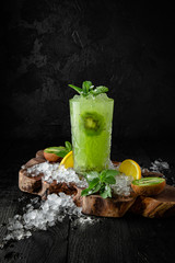 Cocktail with liquor, vodka, syrup, strawberries and kiwi. Cocktail card.  Background black boards. Cocktail card.  Background black boards.