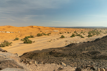 Fototapeta na wymiar Typical desert landscape in the Atlas of the Sahara desert in Morocco with tourist jaimas