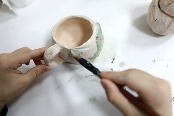Fototapeta na wymiar Person painting clay cup
