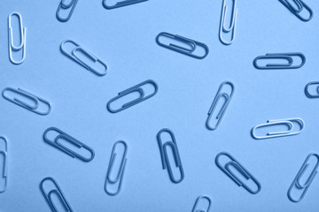 Classic blue background with paper clips pattern, copy space. Color of the year 2020. Top view, flat lay