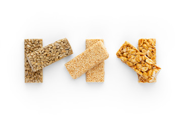 Kozinaki on a white background. Sunflower seeds, peanuts, sesame seeds in caramel close-up. Eastern sweetness. Top View.