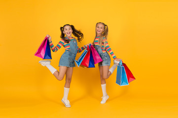 Buyer consumer concept. Small girls with shopping bags. Sales and discounts. Happy children. Little...