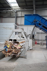 Horizontal hydraulic press for recyclable materials against the wall of a building