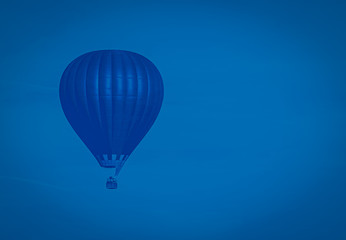 Classical blue colored hot-air balloon flying in the sky, toned