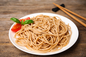 Tasty buckwheat noodles served on wooden table