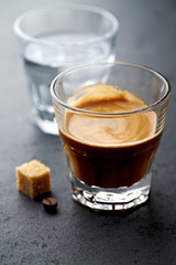  Coffee in glass cup on dark stone background. Close up.