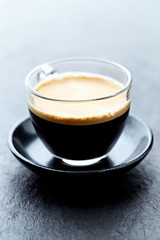 Coffee in glass cup on stone background. Close up. 