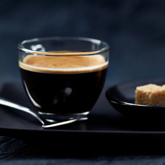 Coffee in glass cup on dark background. Close up. 