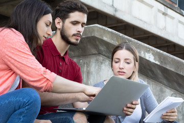 Group of  University students studying together outdoors