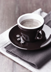 Cup of coffee on rustic wooden background. Close up. 
