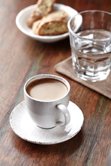 Cup of coffee with cantuccini  (Italian cookies) on rustic wooden background. 