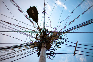 viele Kabel laufen an einer straßenlaterne zusammen