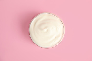 Tasty organic yogurt on pink background, top view