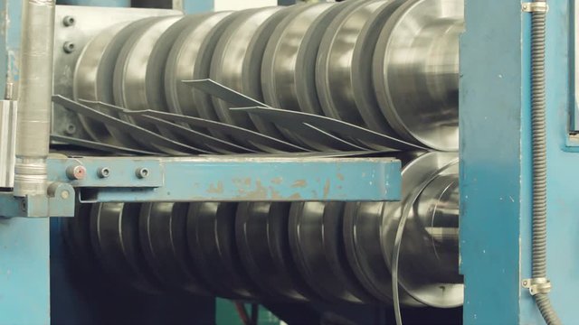 Metal rolls of roll forming machine at a metalwork manufacturing,