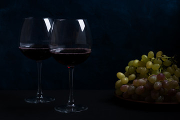 red wine and grapes on a dark background