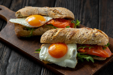  Arugula, salmon and runny egg sandwich, homemade breakfast. 