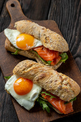  Arugula, salmon and runny egg sandwich, homemade breakfast. 