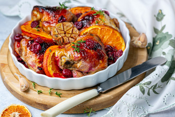 Chicken thighs baked with orange and cherry.