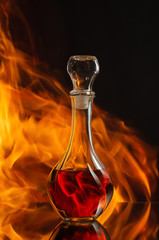 Whiskey in a decanter against a natural flame.