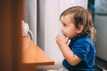 Naklejka premium a little girl yourself holding the mask of the nebulizer, making inhalation