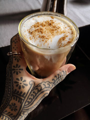 cup of coffee and tattooed female hand 