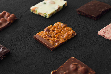 Сhocolate plates flat lay view on dark background, top of view