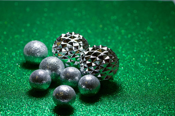 Macro abstract view of glittery silver holiday baubles on a sparkling green background