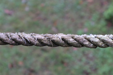 Closeup of a section of weathered and worn thick rope, bokeh background