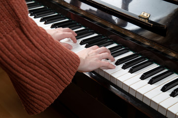 Fototapeta premium Girl playing the piano. Close up . Hands on the keys.