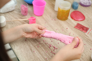 Obraz na płótnie Canvas Little girl making homemade slime toy at table, closeup