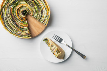 traditional french ratatouille vegetable pie on a white wooden background with cut out slice