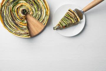 traditional french ratatouille vegetable pie on a white wooden background with cut out slice