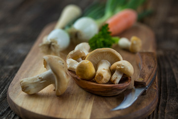 fresh Calocybe gambosa mushroom and knife over wooden cutting board