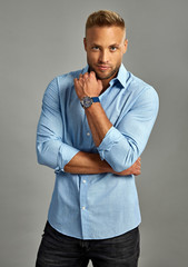 Handsome man with a watch isoalted on gray background