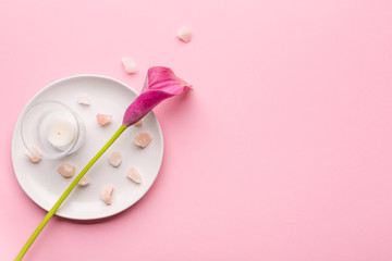 Skin care concept. Sea salt and calla lily flower on a pink pastel background