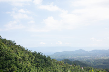 Obraz premium Beautiful top view with sun rays from under the clouds. Magnificent and tropical landscape in Bali, Indonesia.